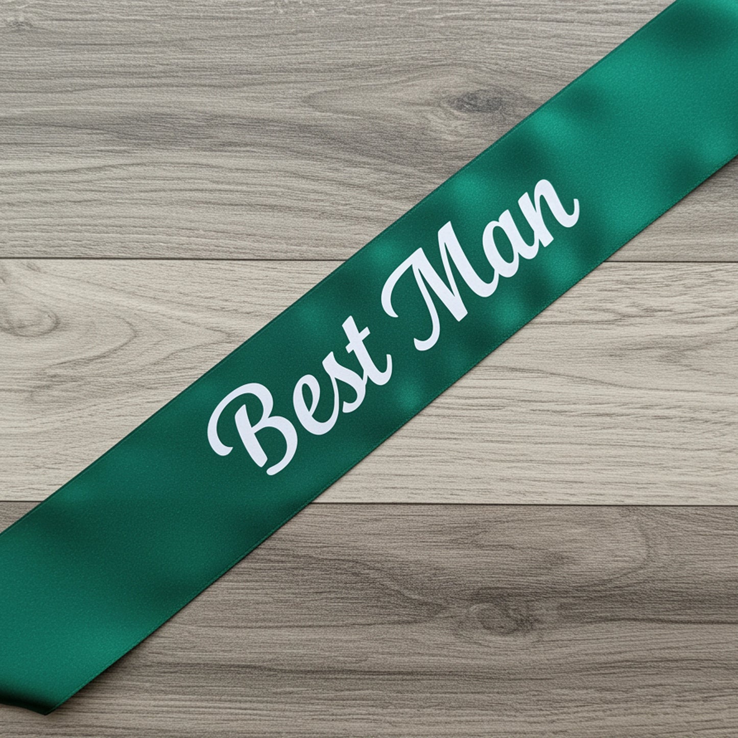 Green sash with 'Best Man' text on a wooden surface
