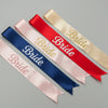 Set of satin sashes with 'Bride' text in various colors on a gray background