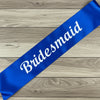 Blue sash with 'Bridesmaid' text on a wooden surface