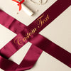Maroon ribbon with 'Custom Text' in gold on a light background