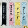 Four customizable satin ribbons in black, pink, gold, and blue on a marble background.