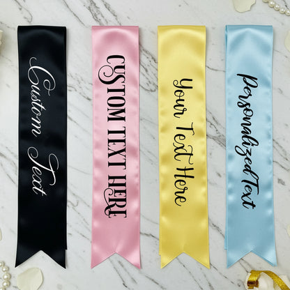 Four customizable satin ribbons in black, pink, gold, and blue on a marble background.